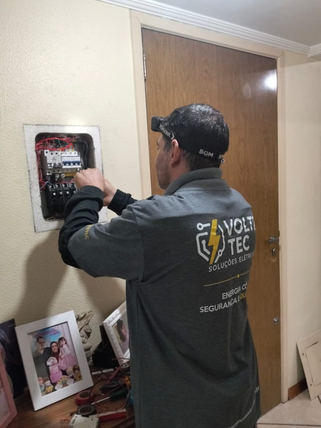 Profissional da VoltzTec trabalhando em quadro residencial