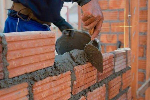 Assentamento de tijolos em parede de alvenaria